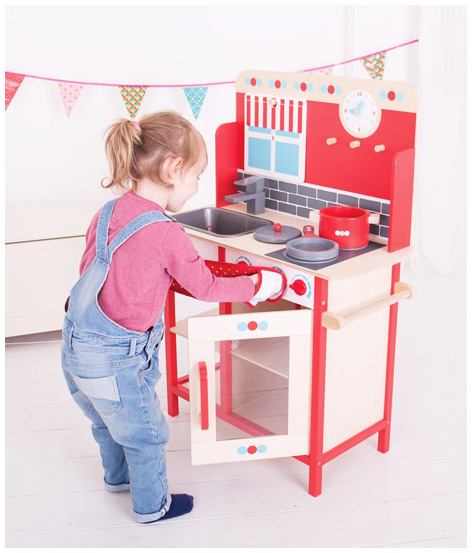 Girl playing with her Bigjigs Play Kitchen